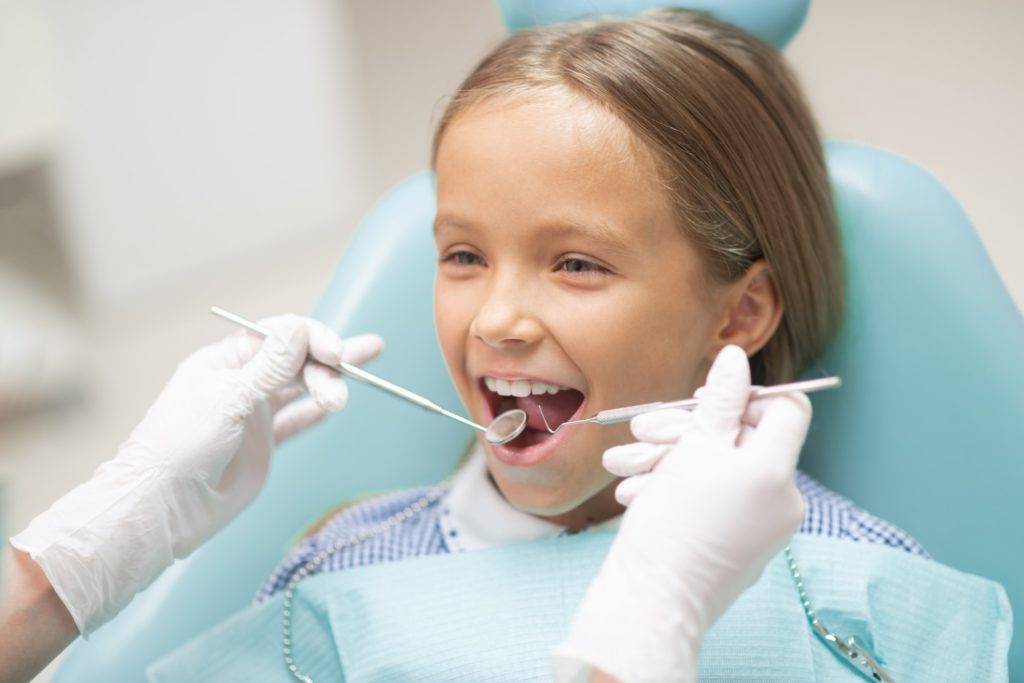 Young Girl in Dentist Chair getting Dental Checkup