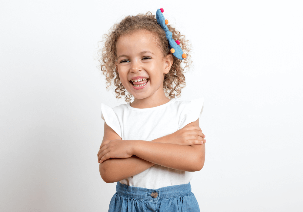 Little girl smiling and crossing her arms